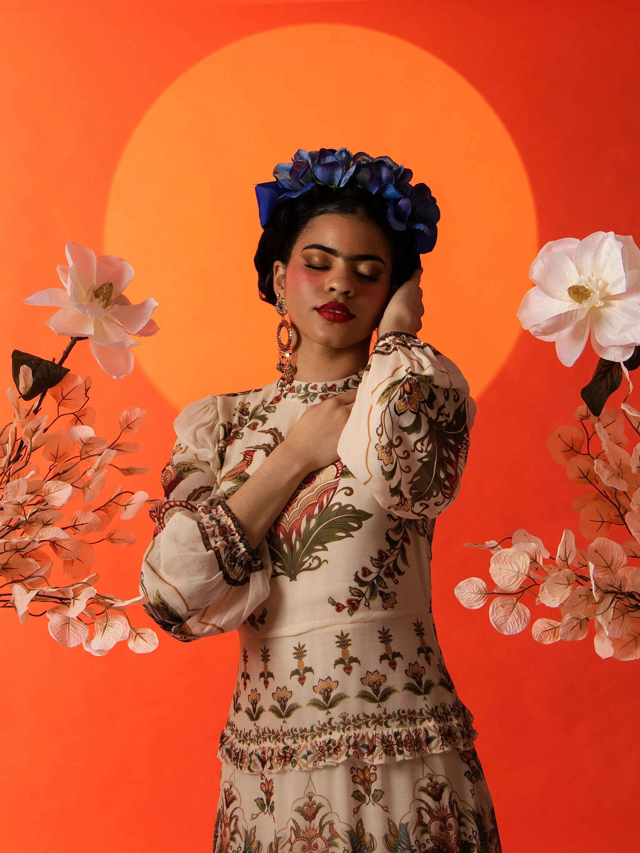 Frida Kahlo inspired editorial makeup with bold red lip and statement brows